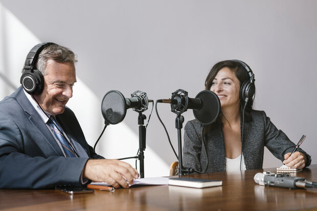 Female broadcaster interviewing her guest in a studio